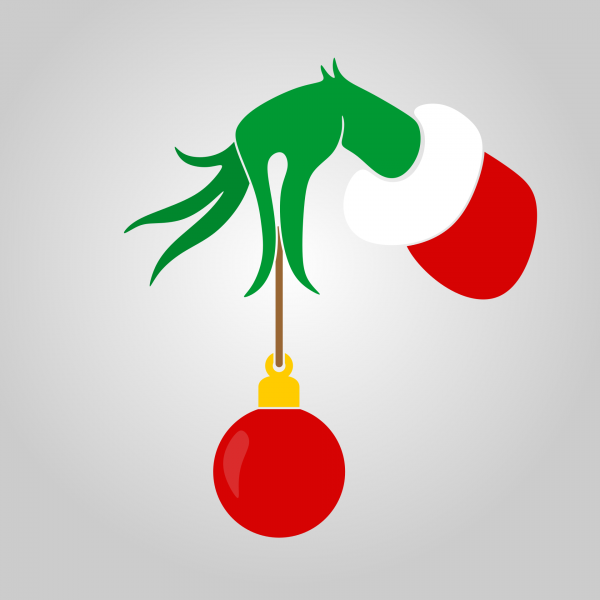 mano verde del grinch che tiene in mano un balocco di natale rosso